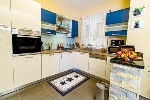 a kitchen with white cabinets and a bowl of fruit on the counter at Apartment Maja with private pool in Sveti Petar