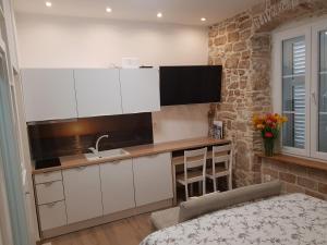 a kitchen with white cabinets and a sink at Studio Apartment B&B Zadar Sunset in Zadar