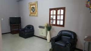 a living room with two chairs and a television at Hotel Confort in Santiago del Estero