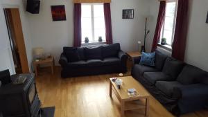a living room with a couch and a table at Det Gule Huset Hurdal in Hurdal