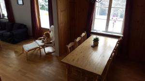 a little girl sitting in a chair next to a table at Det Gule Huset Hurdal in Hurdal