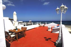 Un patio con mesa y sillas y el mar. en Casa Pura, en Arrieta 9 fotos más