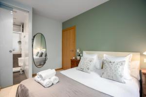 ein Schlafzimmer mit einem großen Bett mit Handtüchern darauf in der Unterkunft Ondarreta Beach Apartment con parking free y Aire acondicionado in San Sebastián