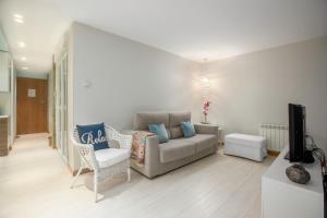 ein Wohnzimmer mit Sofa und Fernseher in der Unterkunft Ondarreta Beach Apartment con parking free y Aire acondicionado in San Sebastián