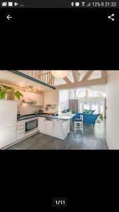 a kitchen with white cabinets and a blue couch at Waldsiedlung in Kröpelin