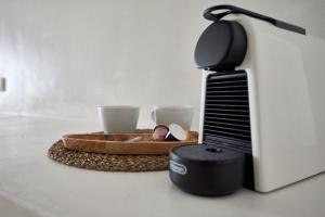 a toaster sitting next to a plate with two cups at Blanco Rooms Mykonos in Mikonos +49 photos