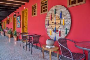 a red wall with tables and chairs and a mirror at Hotel Panchoy by AHS in Antigua Guatemala