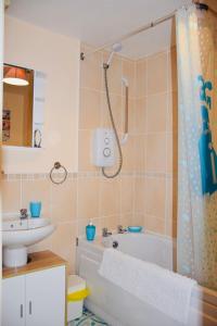 a bathroom with a shower and a tub and a sink at 8 York Mews in Shepton Mallet