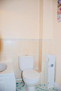 a bathroom with a white toilet and a sink at 8 York Mews in Shepton Mallet