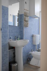 baño de azulejos azules con lavabo y aseo en Moralma, en Sarzana