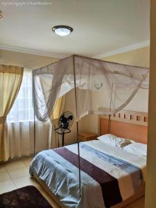 un dormitorio con una cama con dosel en Home Up Guest Apartments and Lodge, en Blantyre