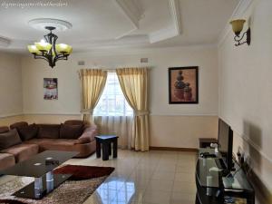 una sala de estar con un sofá y una mesa en Home Up Guest Apartments and Lodge, en Blantyre