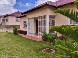 una casa con un jardín delante de ella en Home Up Guest Apartments and Lodge, en Blantyre
