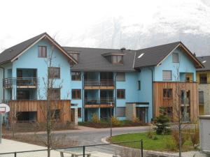 a large blue building with a mountain in the background at Resort Walensee Appartements in Unterterzen