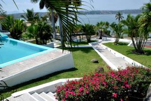 un complejo con piscina y algunas flores en Hotel Infinity, en Tequesquitengo