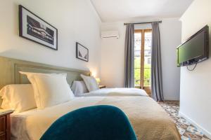 Habitación de hotel con 2 camas y TV de pantalla plana. en Hostal Girona, en Barcelona