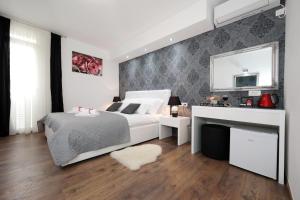 a bedroom with a white bed and a white desk at Zadar Luxury Rooms in Zadar