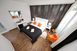 a bedroom with a bed with orange pillows at Zadar Luxury Rooms in Zadar