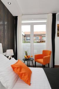 a bedroom with a bed and a chair and a window at Zadar Luxury Rooms in Zadar
