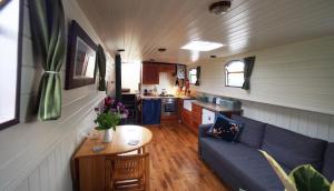 Roisin Dubh Houseboat في Sallins: غرفة معيشة ومطبخ في منزل صغير