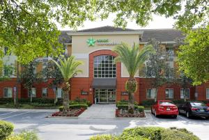 a hotel with a palm tree in front of a building at Extended Stay America Suites - Orlando - Lake Buena Vista in Orlando