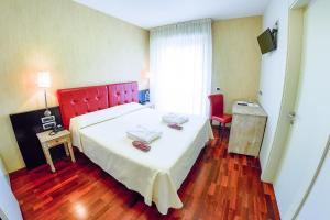 una camera con un grande letto con testiera rossa di Victoria Hotel a Pescara