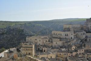 a group of buildings in a town with hills in the background at San Biagio Materapartment in Matera