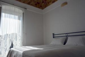 a white bedroom with a bed and a window at San Biagio Materapartment in Matera