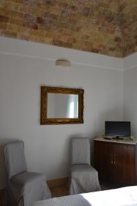 um quarto com duas cadeiras e um espelho na parede em San Biagio Materapartment em Matera