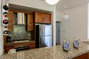 Una cocina con refrigerador de acero inoxidable y gabinetes de madera. en Monserrat Residences, en Las Terrenas