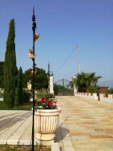 a large vase with flowers in it on a walkway at Albadido in Campomarino