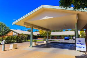 a building with a pavilion with a sign in a parking lot at Country Roads Motor Inn Naracoorte in Naracoorte