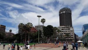 un grupo de personas caminando por una ciudad con un edificio en Magara Suite Las Canteras, en Las Palmas de Gran Canaria
