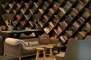 a room with a couch and a wall of books at Wyndham Stuttgart Airport Messe in Stuttgart