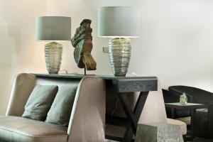 a living room with a couch and a table with two lamps at Wyndham Stuttgart Airport Messe in Stuttgart