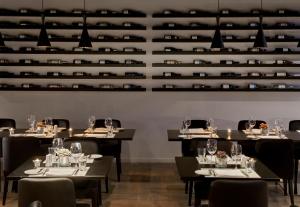 a dining room with tables and chairs and wine racks at Wyndham Stuttgart Airport Messe in Stuttgart