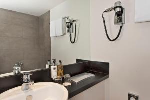 a bathroom with a sink and a mirror at Wyndham Stuttgart Airport Messe in Stuttgart