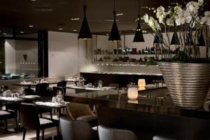 a restaurant with tables and chairs and a vase of flowers at Wyndham Stuttgart Airport Messe in Stuttgart