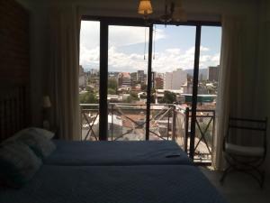 1 dormitorio con cama y ventana grande en La Linda Apart en Salta