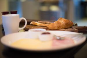 a table with a plate of bread and a cup of coffee at The Sea Beach House in Cortegaça