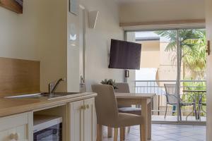 eine Küche mit einem Tisch und ein Esszimmer mit einem Balkon in der Unterkunft Macrossan House Boutique Holiday Apartments in Port Douglas