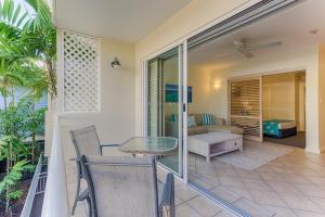 
a living room with a couch and a table at Macrossan House Boutique Holiday Apartments in Port Douglas
