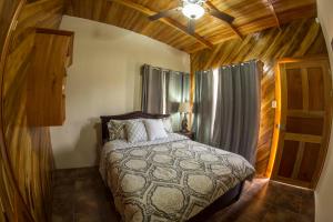 um quarto com uma cama e uma ventoinha de tecto em Villas Fernanda #2 em Fortuna