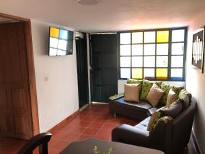 a living room with a couch and some windows at Home Sant Angelo in Villa de Leyva