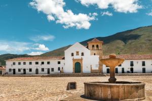 a church with a fountain in front of it at Hostal Home Sant Angelo in Villa de Leyva