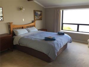 a bedroom with a large bed with two bags on it at Terrace Apartment in Timaru