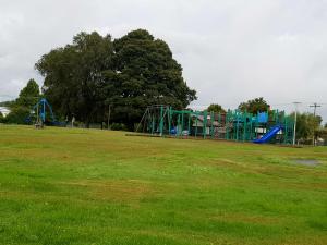 um parque infantil num parque com um campo verde em Central Taupo Townhouse em Taupo