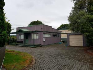 a purple house with a garage on a driveway at Central Taupo Townhouse in Taupo