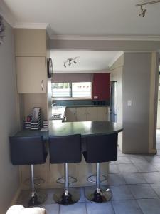 a kitchen with a counter and two bar stools at Central Taupo Townhouse in Taupo