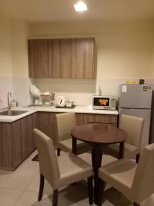 uma cozinha com uma mesa e cadeiras e um frigorífico em Studio Homestay SGarden Resort Residences em Kuantan